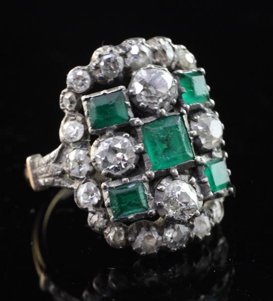 An early 20th century gold, emerald and diamond cluster dress ring, size M.